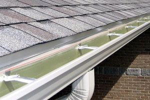 White seamless gutters on a roof with an upgraded architectural shingle roof.